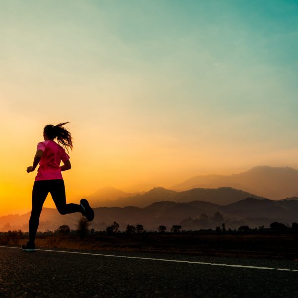 Young woman enjoys running outside with beautiful summer evening in the countryside.